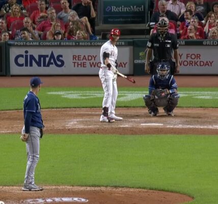 A pitcher facing a batter in a baseball game with spectators in the background