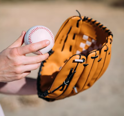 Hand holding a baseball and glove, close-up view