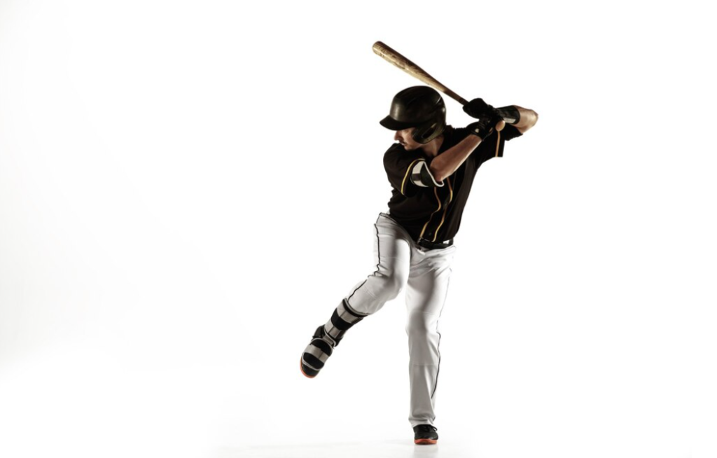 A lone batter in a dark uniform swings powerfully against a white backdrop