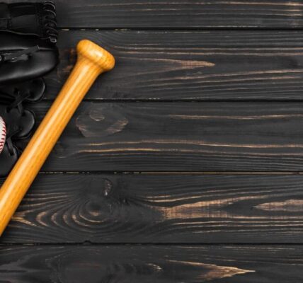 Baseball bat, glove, and ball on dark wooden background