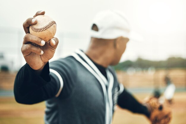 A baseball player holds the ball in his hands and prepares to throw