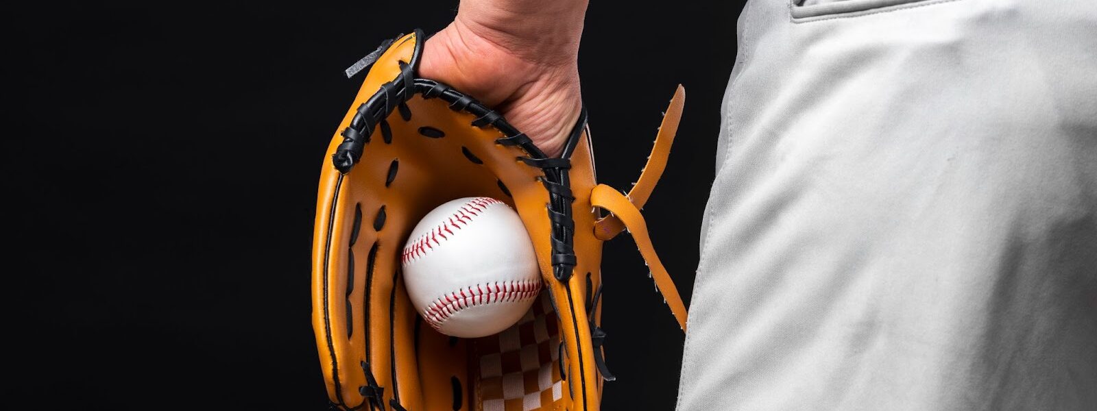 Back view of man holding glove with baseball