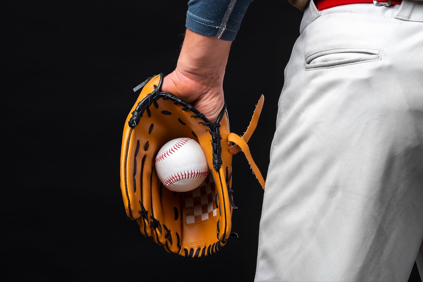 Back view of man holding glove with baseball