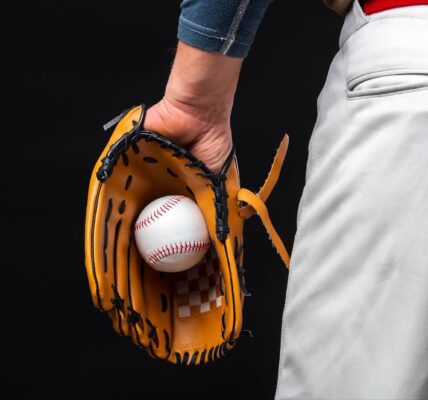 Back view of man holding glove with baseball