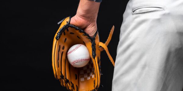 Back view of man holding glove with baseball