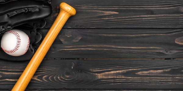 A bat, ball, and glove for playing baseball on a wooden table