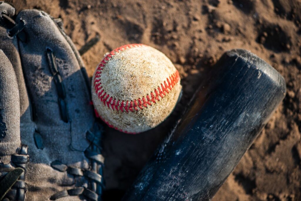 Close up of baseball and bat on the ground