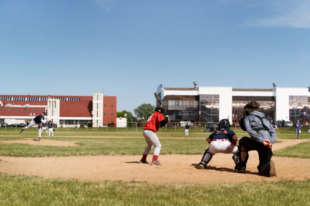 Side view of group of people playing baseball outdoors